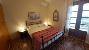 普萨克迪亚ANNAS HOUSE 2b的一间卧室配有一张带红色毯子的床和窗户。