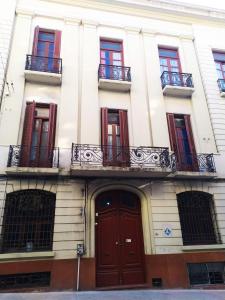 蒙得维的亚Posada Del Gaucho的公寓大楼设有红色门和阳台