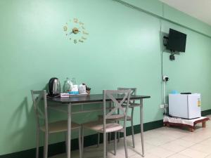 北碧VK &Residence的厨房配有桌椅和墙上的时钟