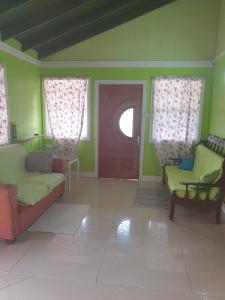 格罗斯岛Seawind Cottage- Traditional St.Lucian Style的客厅配有两把椅子和一扇门