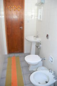乌巴图巴Marujo Hostel的一间带卫生间、水槽和门的浴室