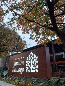 卡斯卡韦尔Pousada Jardim do Lago的一座有树的建筑前面的标志