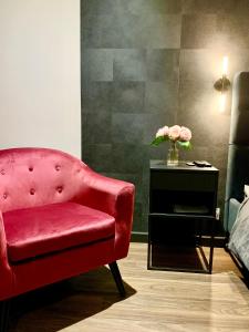 洛里昂Lorient Love Room Le King Size的红椅和花瓶桌子