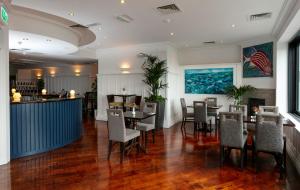 斯卡尔Schull Harbour Hotel & Leisure Centre的一间带桌椅的餐厅和酒吧