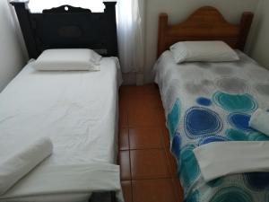 ÁngelesCasa Los Ángeles的两张睡床彼此相邻,位于一个房间里