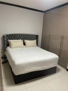 约翰内斯堡2Bedroom Luxury hotel apartment Fourways的一张带白色床单和枕头的床