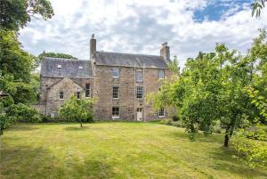 PrestonpansLuxury 5-bed Villa - Winfields House的一座古老的石头房子,有大院子
