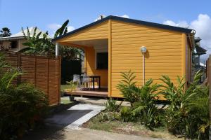 Baie MahaultBungalow Harmony的花园里的一座黄色小房子