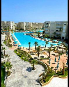 莫纳斯提尔Palm Lake Resort Folla Monastir/Sousse的度假村设有棕榈树和建筑的大型游泳池