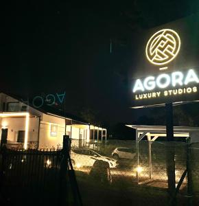 塞萨洛尼基Agora LX Studios & Suites的现代豪华一室公寓的夜间标志