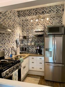 霍卢阿洛阿Hawaii Getaway的厨房配有不锈钢冰箱和瓷砖