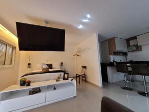 瓜鲁柳斯Via Alameda Studio 706 -GRU-的卧室配有一张床铺,墙上挂着大电视