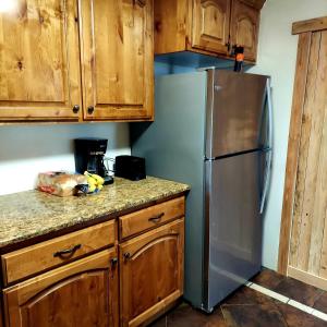 圣安东尼Vintage Cozy Family Home near National Parks的厨房配有不锈钢冰箱和木制橱柜