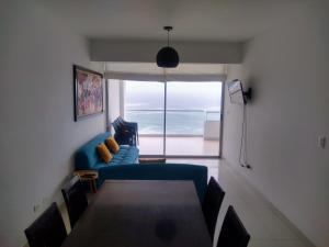 蓬塔赫尔莫萨Departamento en Punta Hermosa con Vista al Mar的客厅配有蓝色的沙发和桌子