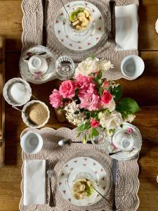 Corticelle PievePiccola Corte Antica的一张桌子上放着盘子和鲜花