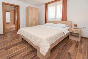 采蒂涅Ethno Village St George的一间卧室设有一张大床,铺有木地板