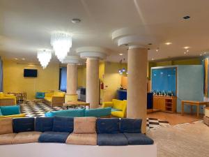 锡尔维玛丽娜Hotel Silvi的大楼内客厅配有沙发和椅子