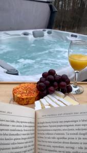 阿尼克什奇艾Rubikiai LUX Duplex Apartamentai的一本书,在热水浴缸旁喝一杯葡萄酒和葡萄