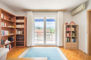 ZmijavciHoliday home Goranka的客厅设有书架和大窗户