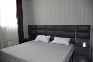 博尔若米Guest House Ana的一张带黑色床头板和两个白色枕头的床