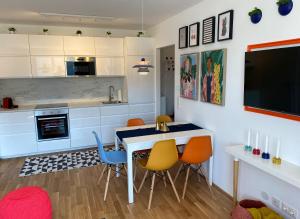 维也纳Brand New Cozy Apartment 10 min to city center的一间带桌椅的厨房和一台电视