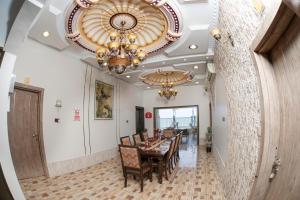 索哈尔Nhar Accommodation House的一间带桌椅和吊灯的用餐室