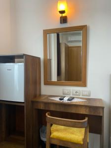 培拉特Hotel Republika Berat的浴室设有梳妆台、镜子和椅子