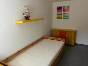 博尔滕哈根Ferienwohnung Mertins的卧室配有一张床,墙上设有架子