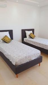 苏塞Appartement Corniche en bord de mer的双床间设有2张单人床。