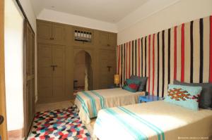 塔鲁丹特Dar al Hossoun的一间卧室设有两张床和条纹墙