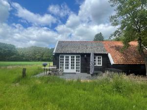 WijheNatuurhuisje - Gastenverblijf De Kleine Hazerij的小屋在野外设有野餐桌