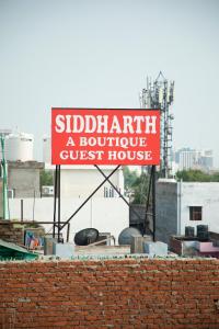 新德里Hotel Siddharth A Boutique Guest House的砖墙屋顶宾馆的标志