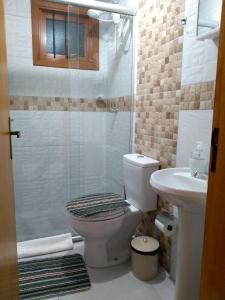 格拉玛多Casa e Flat Conforto Gramado的带淋浴、卫生间和盥洗盆的浴室