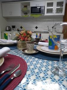 格拉玛多Casa e Flat Conforto Gramado的桌子上摆有盘子和餐具