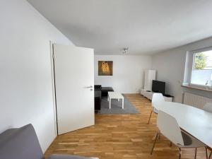 康斯坦茨FeWo "Obere Bündt"的客厅配有白色的桌子和椅子