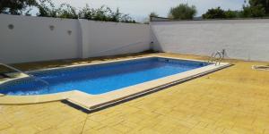 阿尔加尔Alojamiento rural " Las Carmenes "的一座位于庭院的游泳池,拥有白色的墙壁