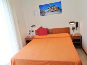 里米尼Hotel Lariana的一间卧室配有一张带橙色床罩的床