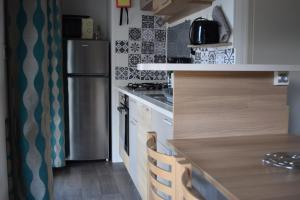 翁赞Mobil Home tout confort 6 personnes avec wifi的厨房配有冰箱和台面