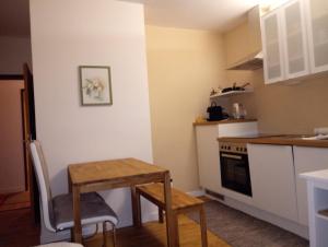 玛利亚采尔Gössl, Apartement und Doppelzimmer的小厨房配有木桌、桌子和桌子