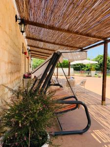 莫迪卡Il Casale di Luisa的木屋顶下的长凳,配有雨伞
