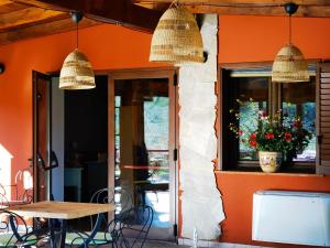 特雷斯努拉吉斯La Corte degli Ulivi - Albergo Rurale的餐厅拥有橙色的墙壁和桌椅