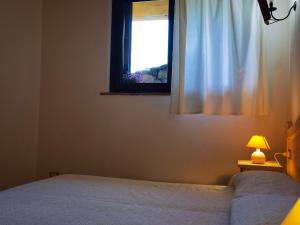 特雷斯努拉吉斯La Corte degli Ulivi - Albergo Rurale的一间卧室设有一张床和一个窗口