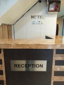 贾纳克布尔Hotel Sara PVT LTD的柜台上的酒店标志