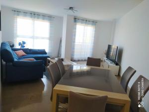 AdorApartamento en sol, Ador的客厅配有桌子和蓝色沙发