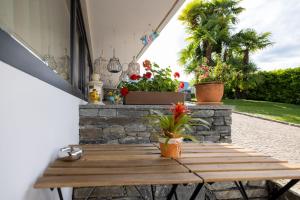 阿斯科纳Casa Alice Ascona, appartamento di vacanza.的庭院里一张带鲜花的木桌