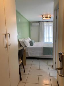 巴雷里尼亚斯Gran Lençóis Flat Residence Mandacaru 311 - 611的一间卧室配有一张床、一张桌子和一个窗户。
