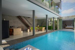 坎古Sandhya Villa Canggu Echo Beach的游泳池,位于带客厅的房屋内