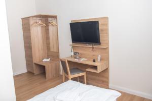 汉恩明登Hotel Fulda的客房设有一张桌子、一台电视和一张床