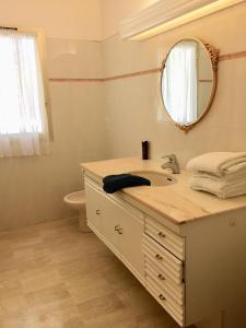 格雷乌莱班塞维尼别墅酒店的一间带水槽、镜子和卫生间的浴室