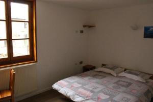 蒙乃第耶-勒潘Gite l'Aiguillette du Lauzet的一间卧室设有一张床和一个窗口